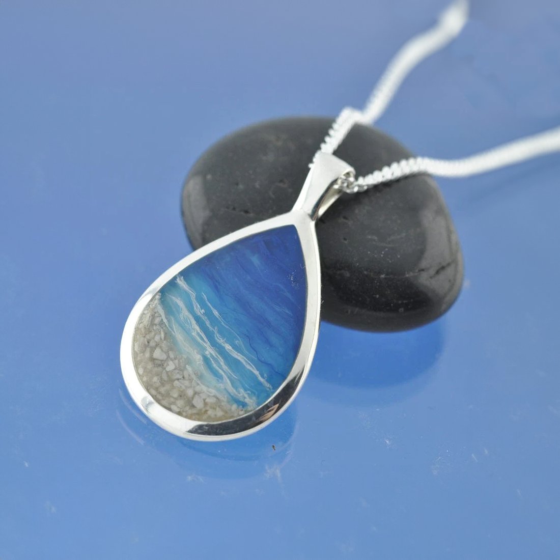 A cremation ashes necklace in the style of a beach. A teardrop pendant with your loved ones cremated ashes. Perfect memorial pendant