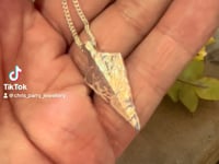 ashes necklace video showing a flint style arrowhead with cremation ashes inside. 