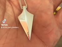 ashes necklace in the style of a smooth arrowhead, with your loved ones ashes inside.