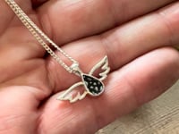ashes necklace, a small tear drop shape with delicate angel wings either side. 
